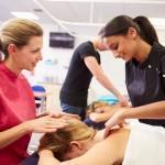 Teacher Helping Student Training To Become Masseuse