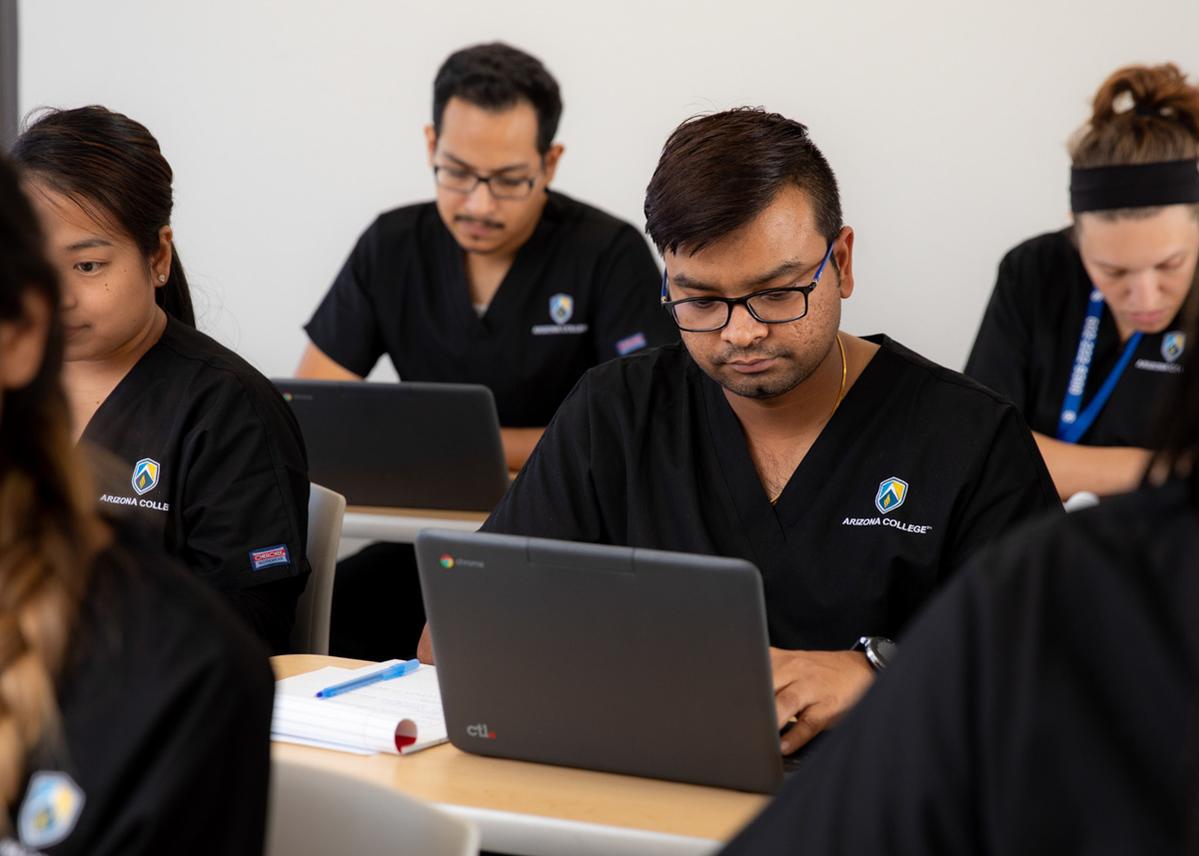 Healthcare Student at his laptop at Arizona College