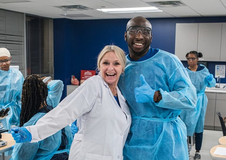 BSN Nursing Program Student With Faculty In Lab Coat