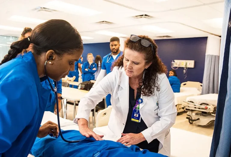 Nursing Program Near Me Faculty With Students In Nursing School Lab earning a nursing degree